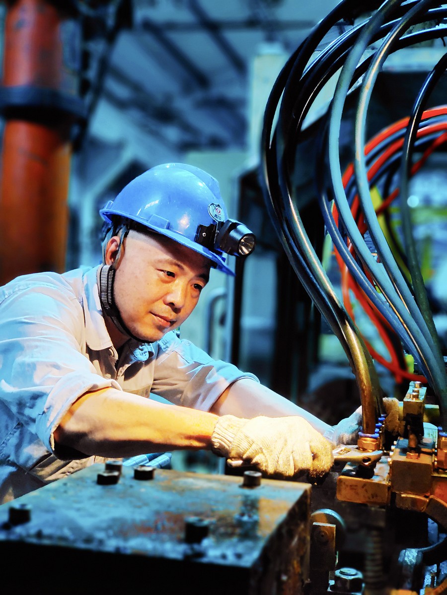 东风设备制造有限公司员工张波在狭小闷热的空间里维修设备 通讯员 杜